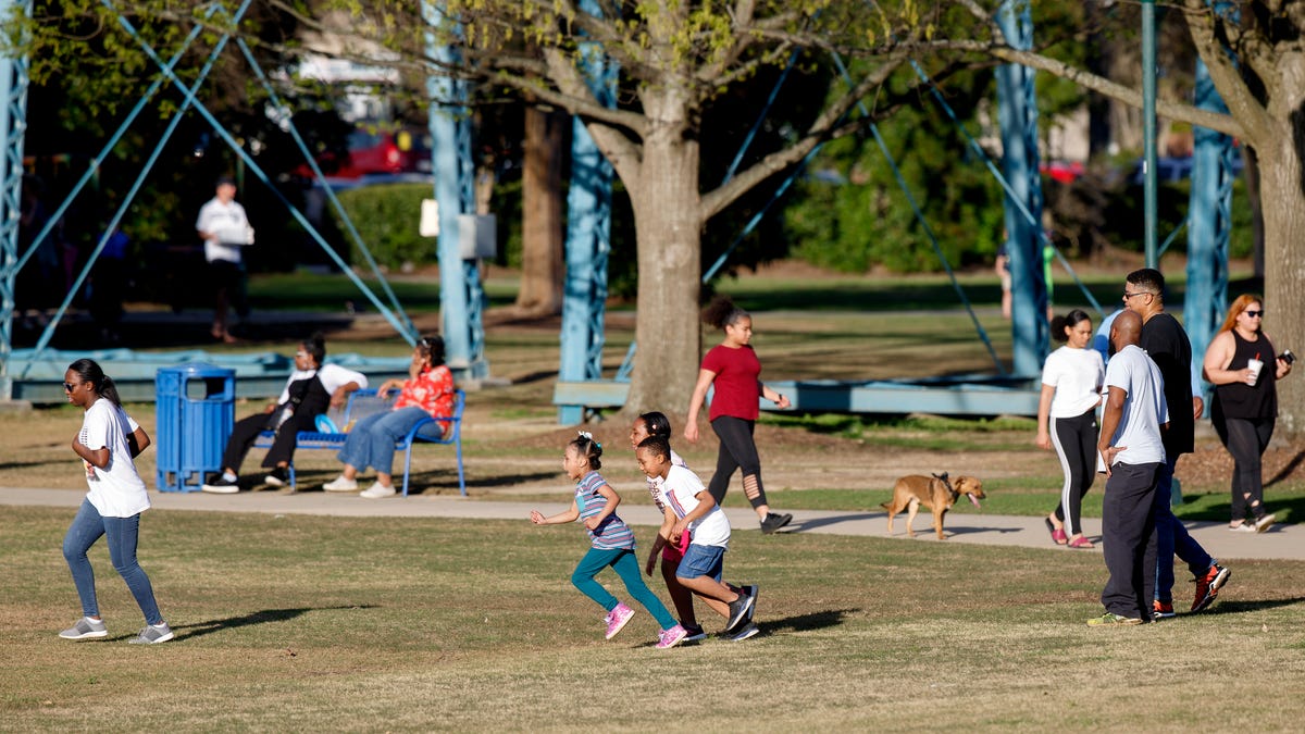 People play and enjoy the weather at Coolidge Park on Thursday, March 26, 2020, in Chattanooga, Tenn. Despite the coronavirus, people gathered at the park, albeit in smaller numbers than usual.