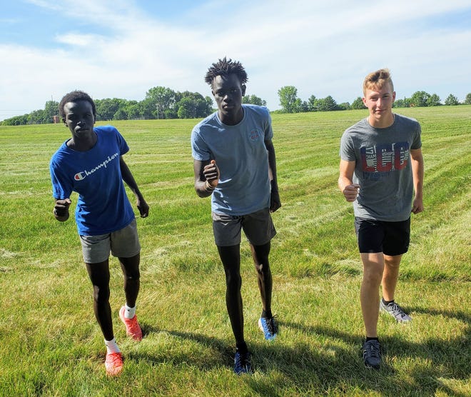 Ajol Akok (left), Ainey Akok (center) and Bennett Ryken hope to lead the Ames boys' cross country team to a high placing at state in 2020.