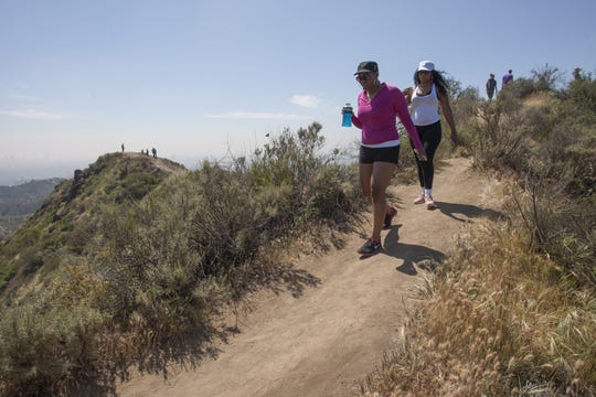 People hike along a ridge where vegetation is quickly drying out in Griffith Park on March 29, 2015, in Los Angeles.