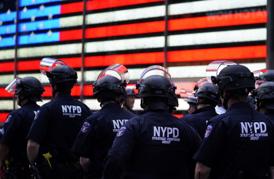In this file photo  NYPD police officers watch demonstrators in Times Square on June 1, 2020, during a "Black Lives Matter" protest.