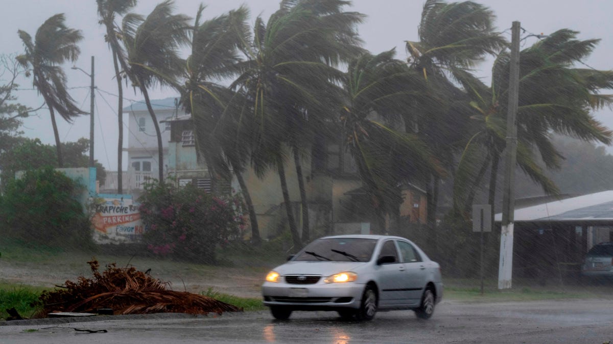 A car drives on a road as Tropical Storm Laura hits Guayama, Puerto Rico on Aug. 22, 2020. 