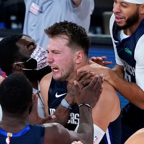 Luka Doncic, center, celebrates with teammates aft