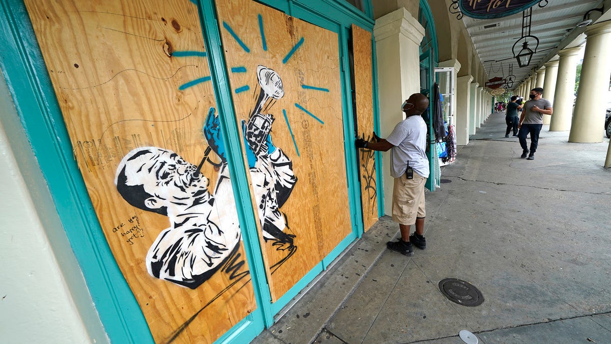 Workers board up shops in the French Quarter of New Orleans, Sunday, Aug. 23, 2020, in advance of Hurricane Marco, expected to make landfall on the Southern Louisiana coast. 