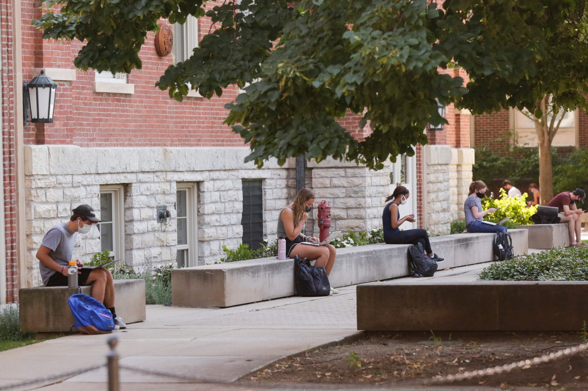 Students sit spaced out by Purdue's University Hall on Aug. 24 in West Lafayette, Indiana.