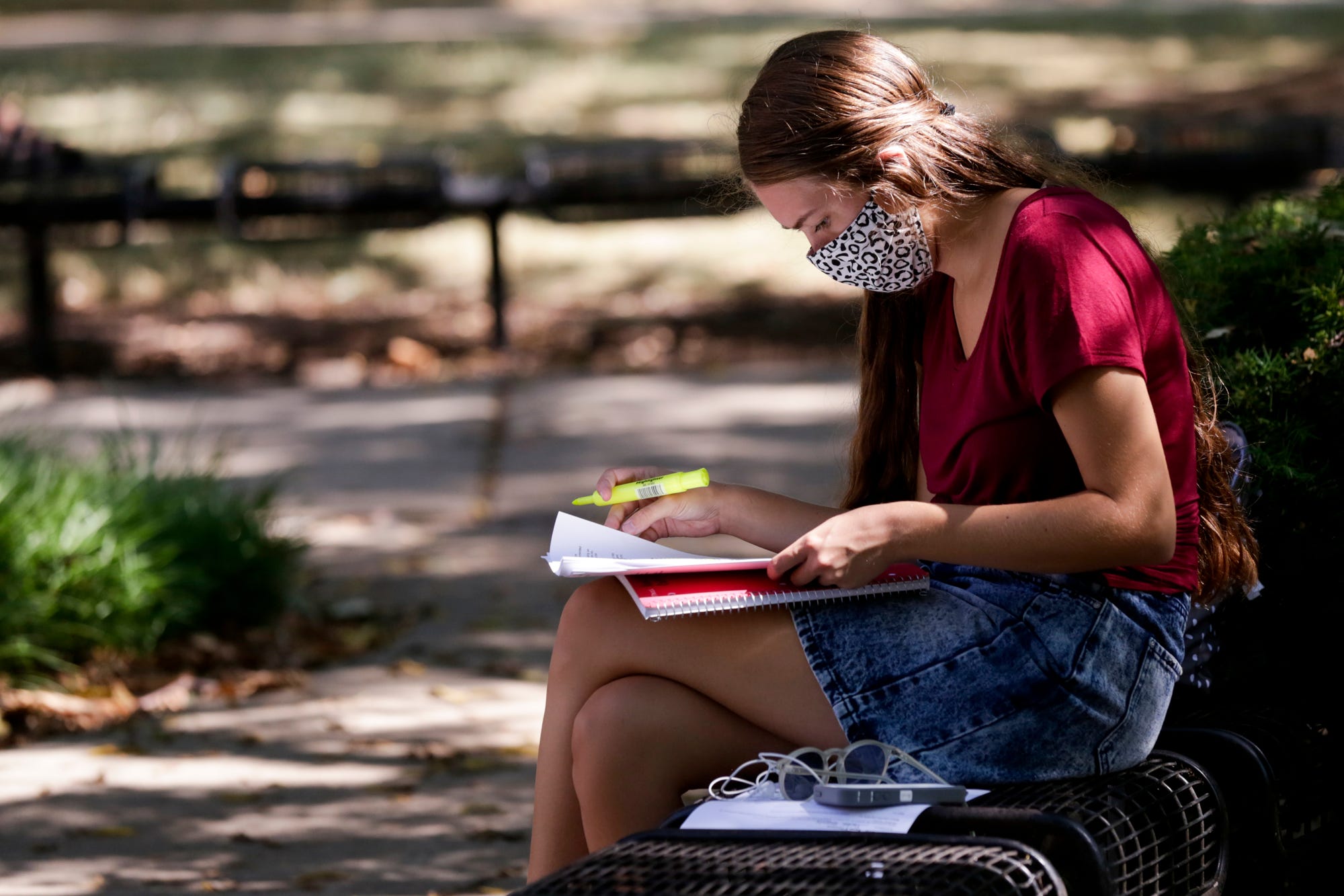 Sarah Connors, a senior animal science major at Purdue University, sits in the shade by the Purdue Bell tower before her afternoon classes Monday in West Lafayette.