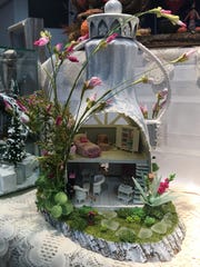 Muncie artist Linda Farris used a Tropicana orange juice plastic bottle to create a miniature house that was featured in the May/June 2020 issue of Miniature Gazette magazine. The entryway of the house featured HGTV-inspired ¼”=scale sliding barn-doors that Farris designed, engineered and fabricated.
