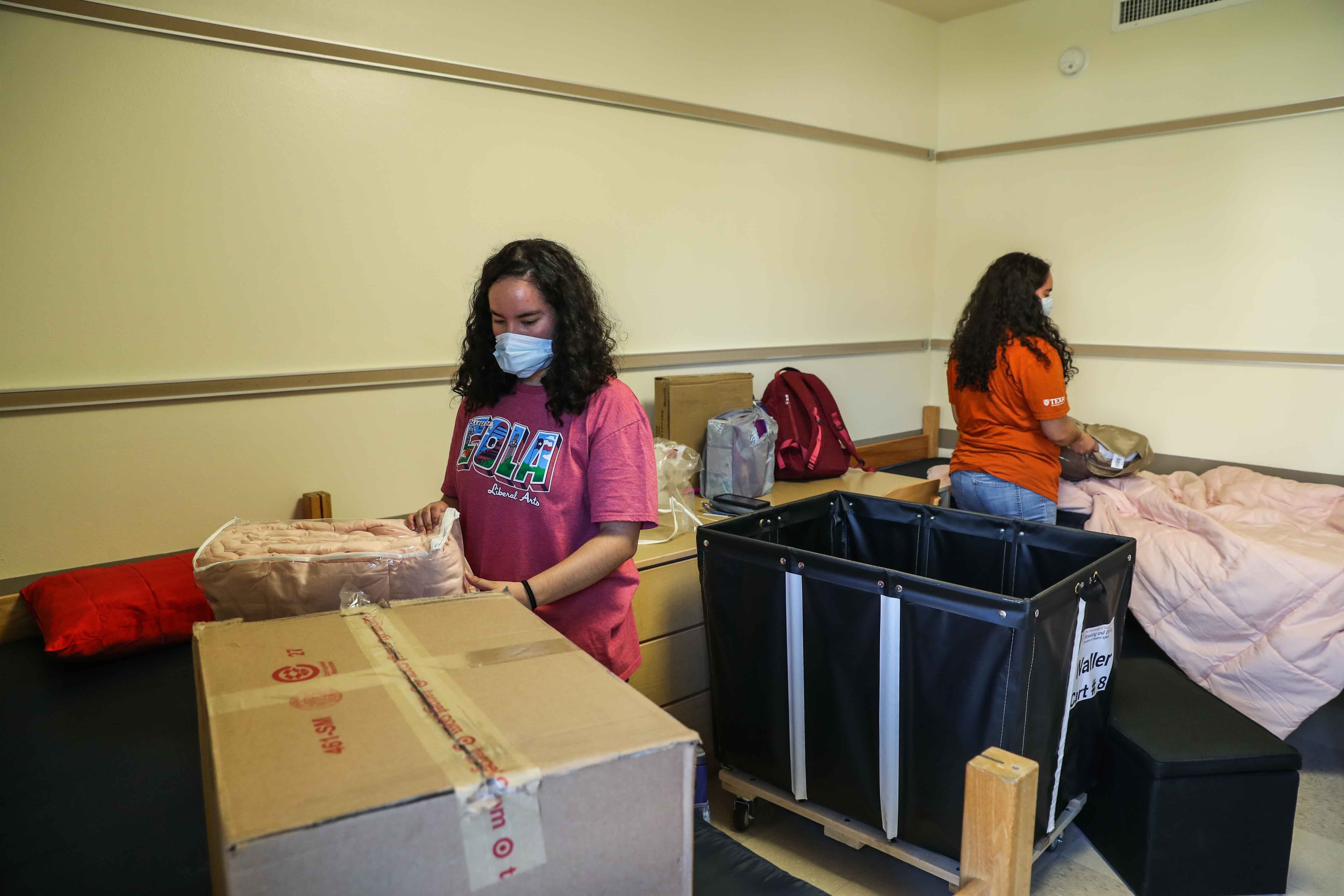 Alexis and Alyssa Hernandez start to unpack their belongings after arriving in their new room in the Jester West Dormitory at the University of Texas in Austin on Thursday, August 20, 2020.