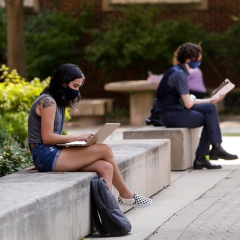 Student's sit outside University Hall at Purdue Un