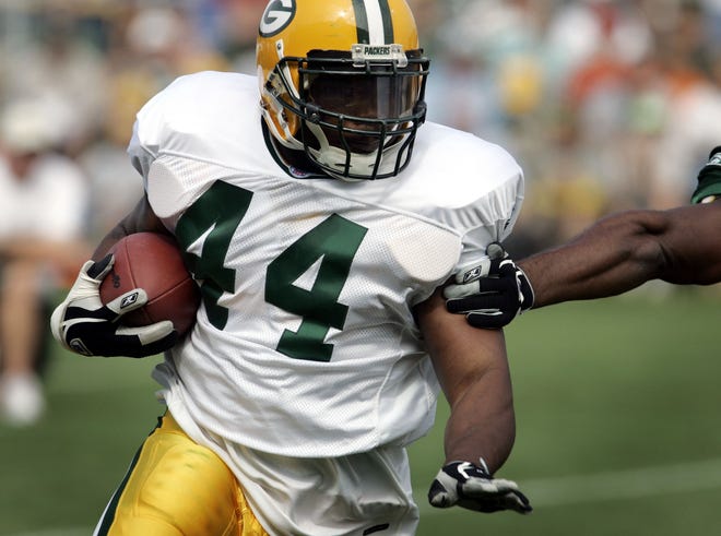 Text: PACKERS 2.-Packers running back Najeh Davenport runs past an arm tackle during training camp Tuesday August 3, 2004 in Green Bay, WI. Photo by Tom Lynn