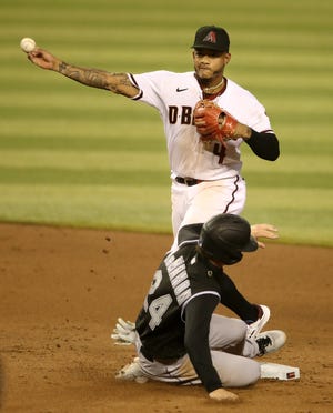 PHOENIX, ARIZONA - AUGUST 24: Infielder Ketel Marte #4 of the Arizona Diamondbacks throws over Ryan McMahon #24 of the Colorado Rockies to complete a double play during the eighth inning of the MLB game at Chase Field on August 24, 2020 in Phoenix, Arizona. (Photo by Christian Petersen/Getty Images)