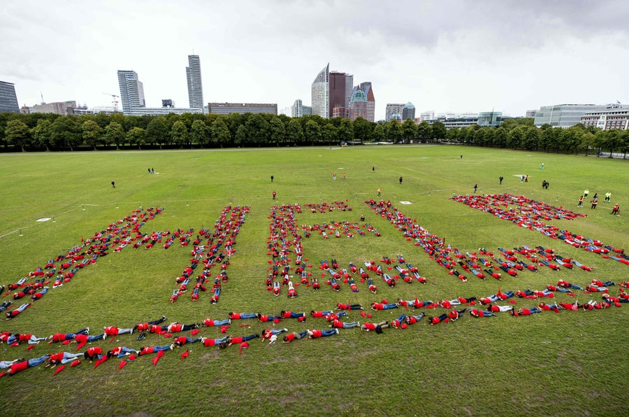 People lie on the grass in the Malieveld to form a message that reads "help" during a protest in The Hague, The Netherlands, on August 25 to highlight the lack of work due to the COVID-19 lockdown.