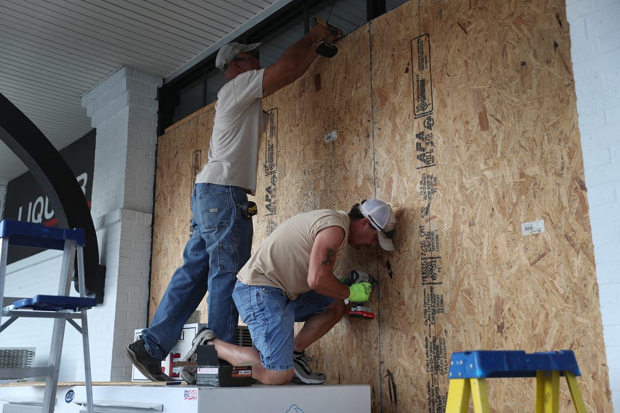 Wesley Jacobs and David Bouillion board up the windows on a business before the possible arrival of Hurricane Laura on August 25, 2020 in Lake Charles, Louisiana.