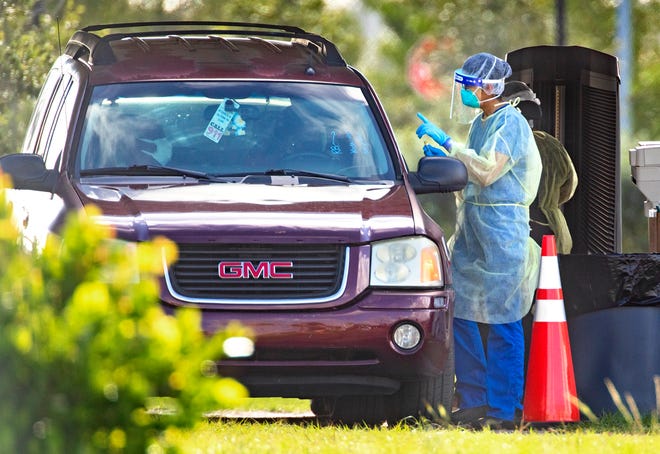 A person is tested for COVID-19 at the FitTeam Ball Park of the Palm Beaches drive-thru in West Palm Beach.