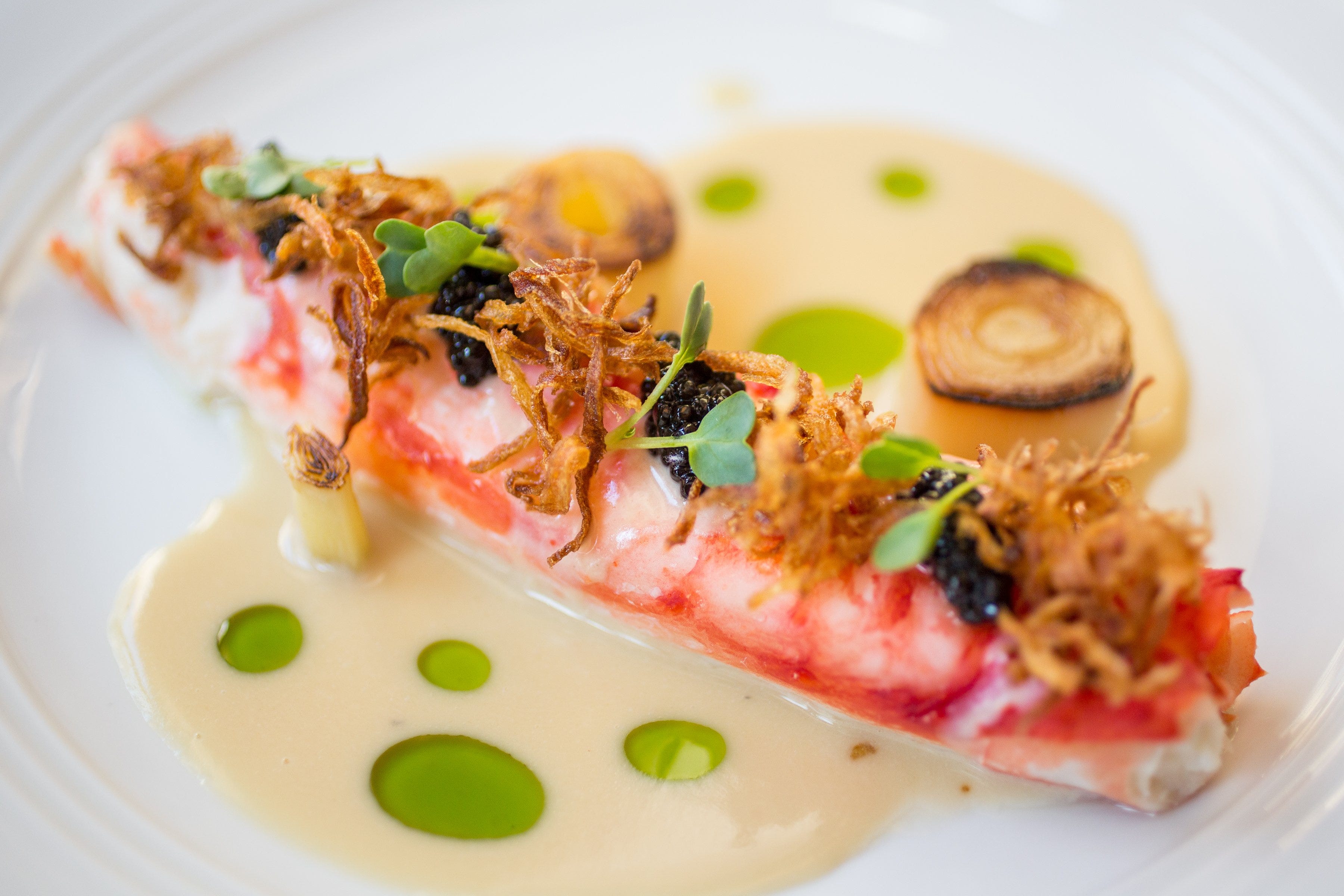 Butter-poached king crab leg with caviar, leeks, lemon and roasted garlic butter at Lionfish. The San Diego-born restaurant debuts in Delray Beach this spring. [Provided by Clique Hospitality]