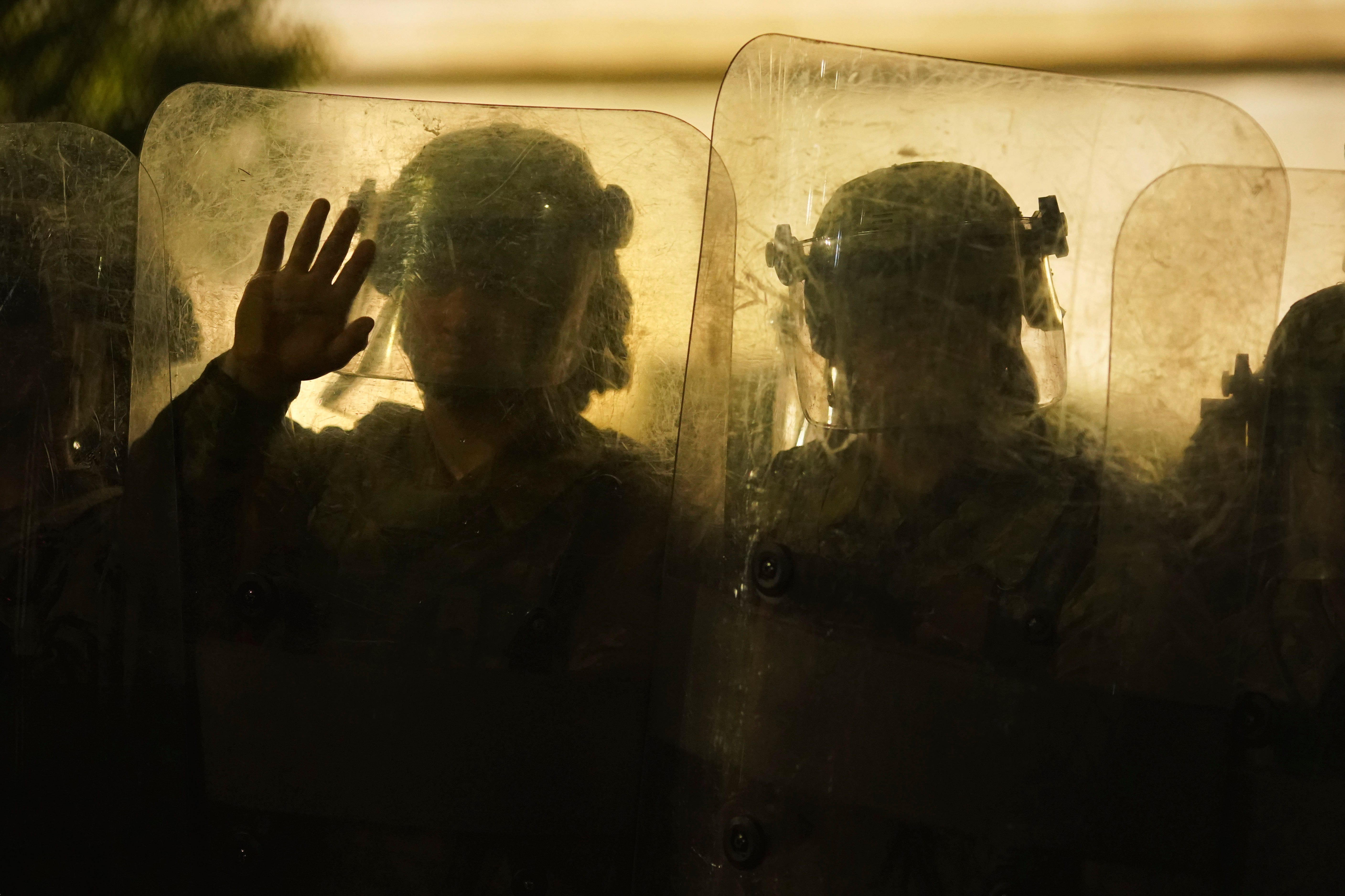 Law enforcement in riot gear line up against protesters during clashes outside the Kenosha County Courthouse late Tuesday, Aug. 25, 2020, in Kenosha, Wis.