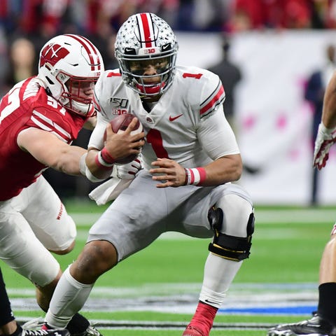 Ohio State quarterback Justin Fields tries to avoi