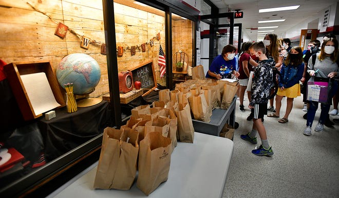 Jill Hockycko, the breakfast cook at Conemaugh Townhip high school in Davidsville, Pa., hands out brown bag breakfast meals to arriving students on the first day of school. Wednesday, Aug. 26, 2020. The bags contained juice, milk, cereal and cinnamon rolls.