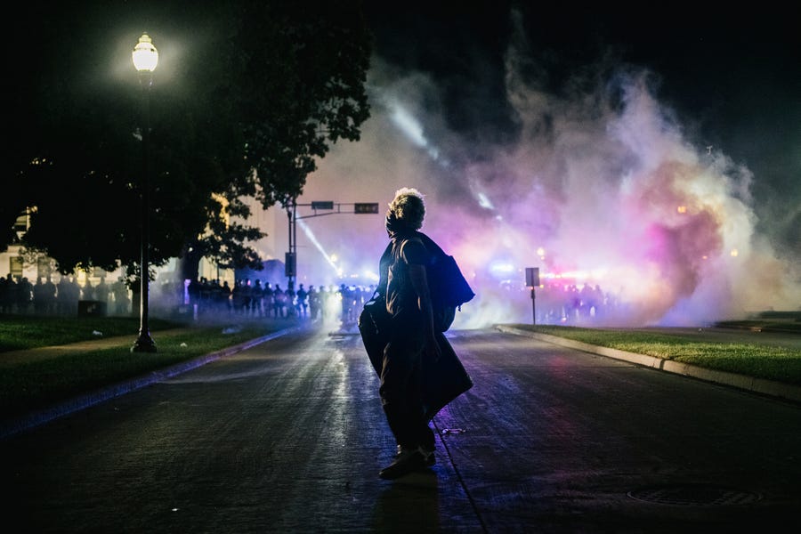 A demonstrator stands in the street with a make-shift shield on August 25, 2020 in Kenosha, Wisconsin. As the city declared a state of emergency curfew, a third night of civil unrest occurred after the shooting of Jacob Blake, 29, on August 23.