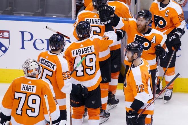 Philadelphia Flyers right wing Jakub Voracek (93) high fives teammates as they leave the ice following their overtime victory in an NHL Stanley Cup Eastern Conference playoff hockey game against the New York Islanders in Toronto, Ontario,  Wednesday, Aug. 26, 2020.