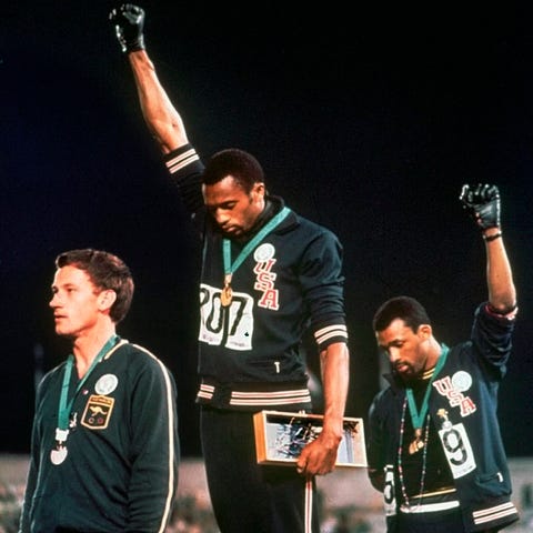 John Carlos (right) and Tommie Smith stare downwar