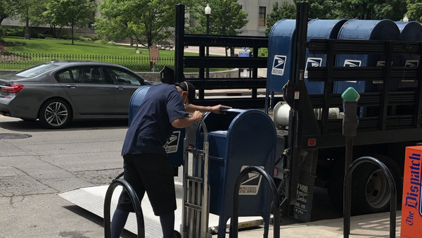 A Postal worker removes mailboxes in downtown Colu
