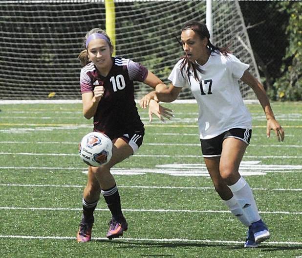 John Glenn's Caroline Lee (10) attempts to take control of the ball before New Philadelphia's Chloe Wing (17) during the girls soccer game on Saturday at John Glenn High School.