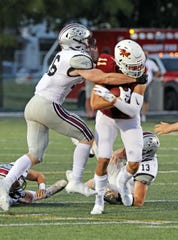 Ankeny High senior wide receiver and Iowa commit Brody Brecht (11) is tackled by Ankeny Centennial senior defensive back Tyler Johnson (26) as the No. 7 Ankeny Centennial Jaguars battle against the No. 2 Ankeny Hawks in the first half of play at the JagHawk Bowl during the Class 4A season opener on Friday, August 28, 2020 at Ankeny Stadium. 