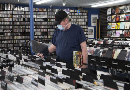 Scott Lewis looks at the selection of records at The 'In' Groove in Phoenix on Aug. 29, 2020. Record stores across the Valley open up for Record Store Day and adapt to the challenges COVID-19 presents.