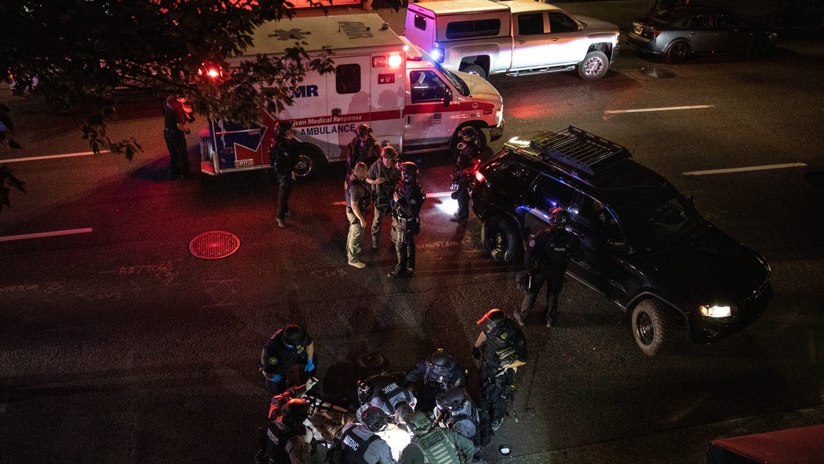 A man is treated by medics after being shot during a confrontation Aug. 29 in Portland, Ore. Fights broke out downtown as a large caravan of supporters of President Donald Trump drove through the city, clashing with protesters.