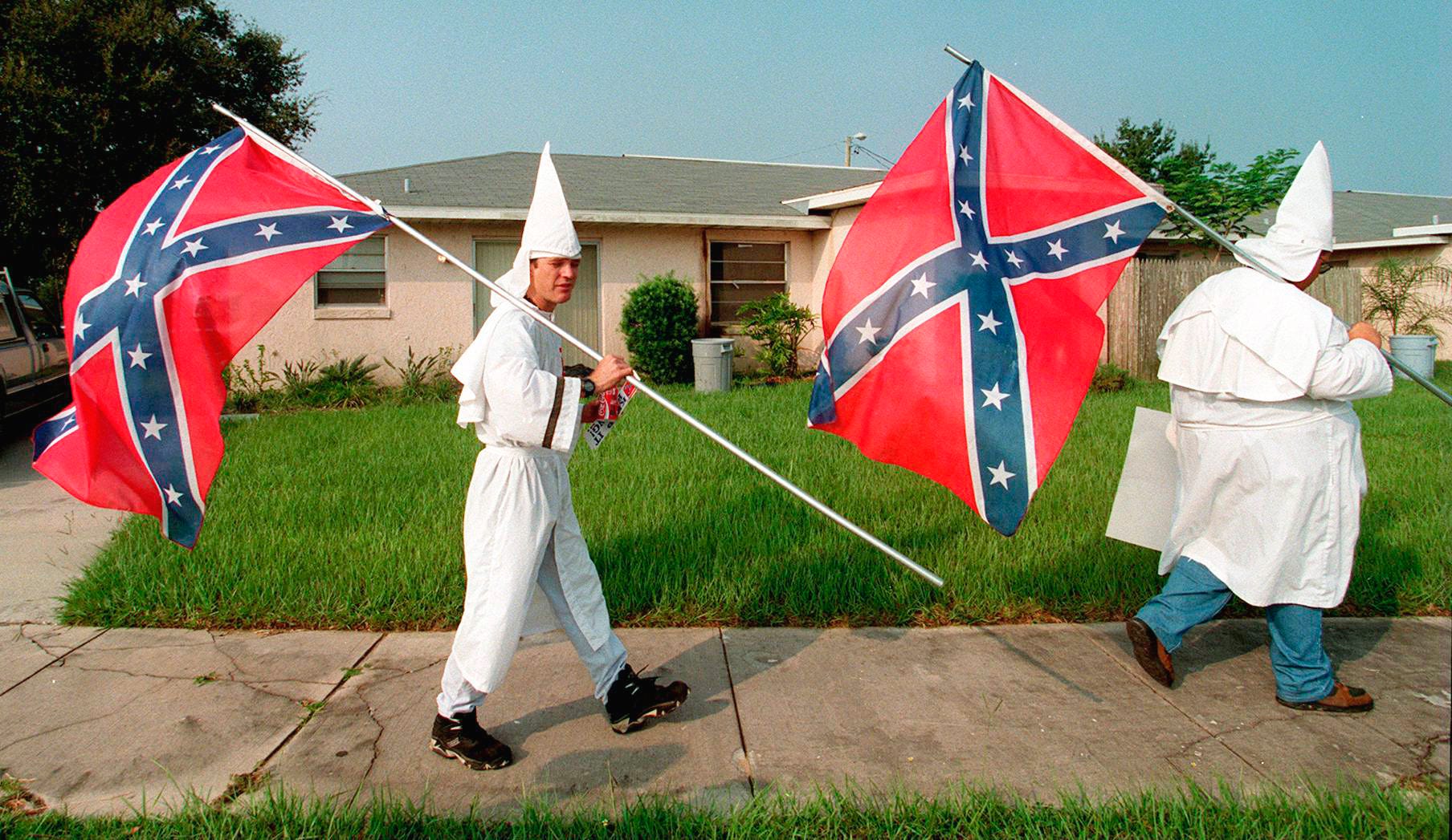 Ku Klux Klan members walk back to their cars after protesting across from Auburndale High School on  Aug. 18, 1995. A group of six Klan members protested to show support for an Auburndale High School student's right to wear the Confederate flag.