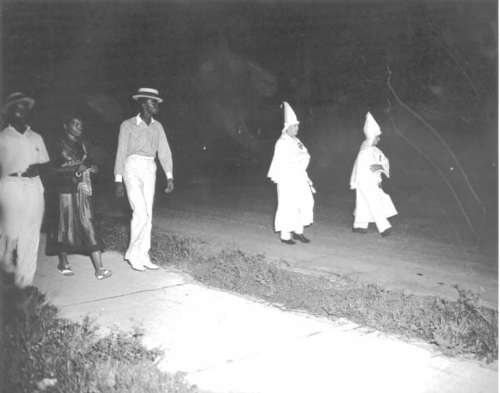 Members of Lakeland's Black community confront members of the Ku Klux Klan, who marched along Dakota Avenue, now Martin Luther King Jr. Boulevard, in 1938.