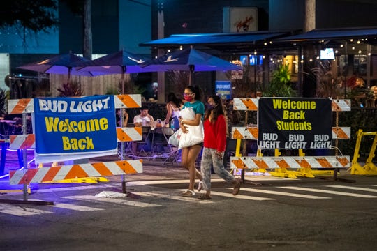 People walk along South University Avenue in Ann Arbor, Mich on Aug. 28, 2020.