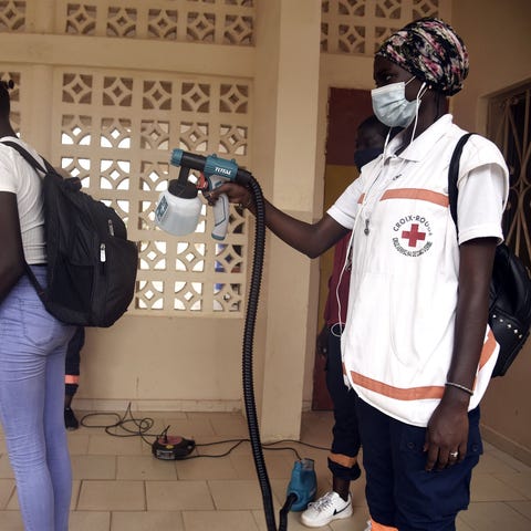 A Red Cross worker sprays a pupil with a disinfect