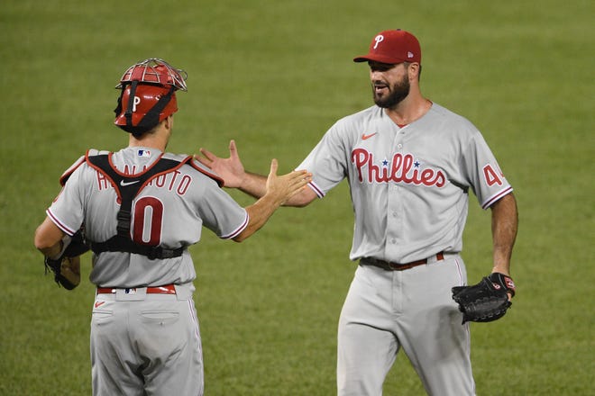 Phillies closer Brandon Workman, right, shakes hands with catcher J.T. Realmuto after finishing a 3-2 win over the Nationals.