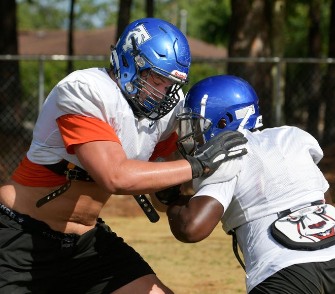 Trinity Christian offensive tackle Austin Barber (left), a Super 11 selection, blocks during preseason high school football practice. Barber, who helped Trinity to the Class 3A state title on Wednesday night, committed Thursday night to the University of Florida.