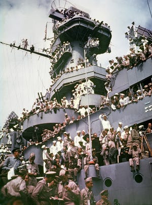 In this Sept. 2, 1945, file photo, servicemen, reporters, and photographers perch on the USS Missouri for the onboard ceremony in Tokyo, in which Japan surrendered, ending World War II.