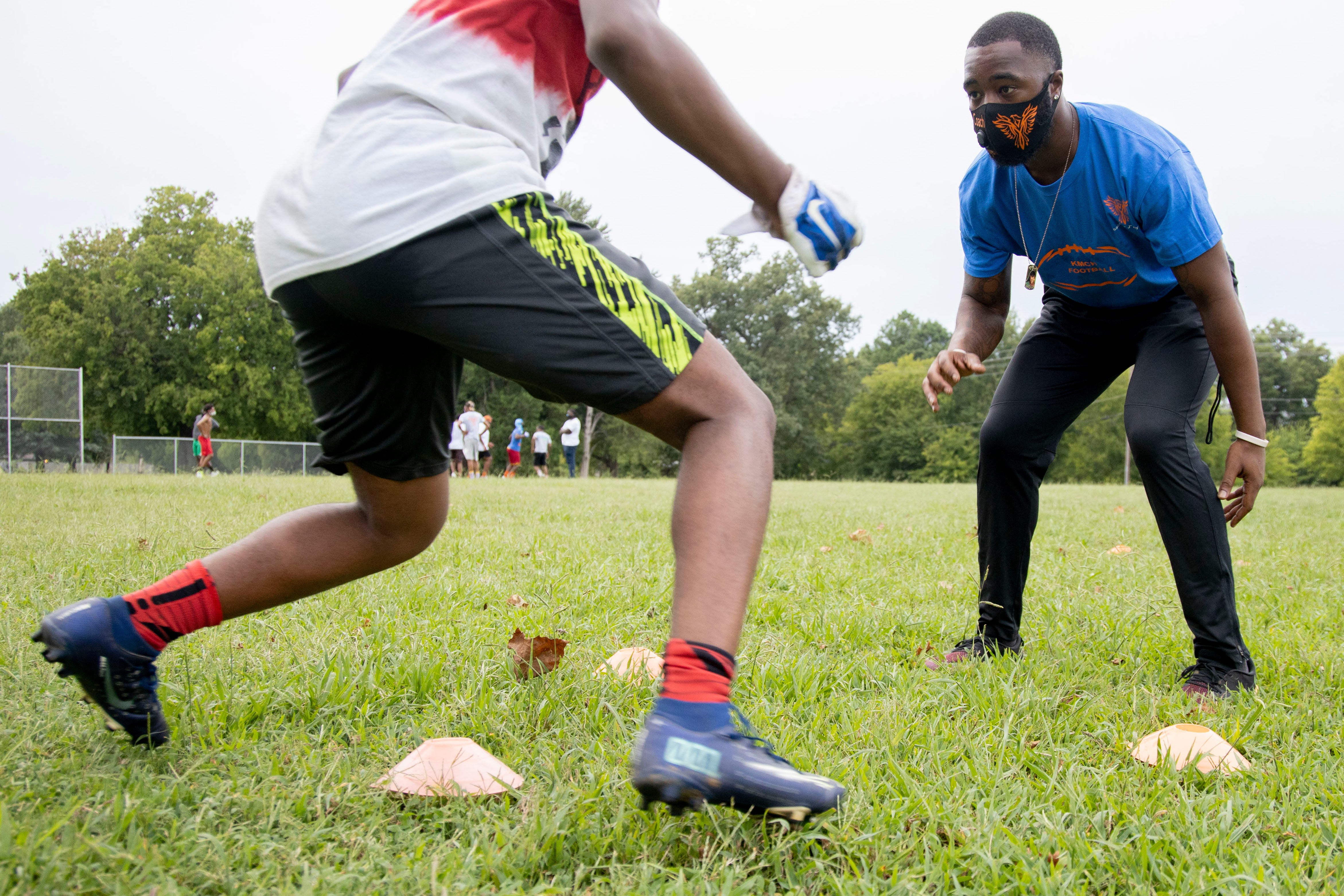 Football coach T.J. Ayers (right) guides Melikah Stokes, 14, through a conditioning drill Tuesday, Sept. 1, 2020, at KIPP Memphis Collegiate High School.