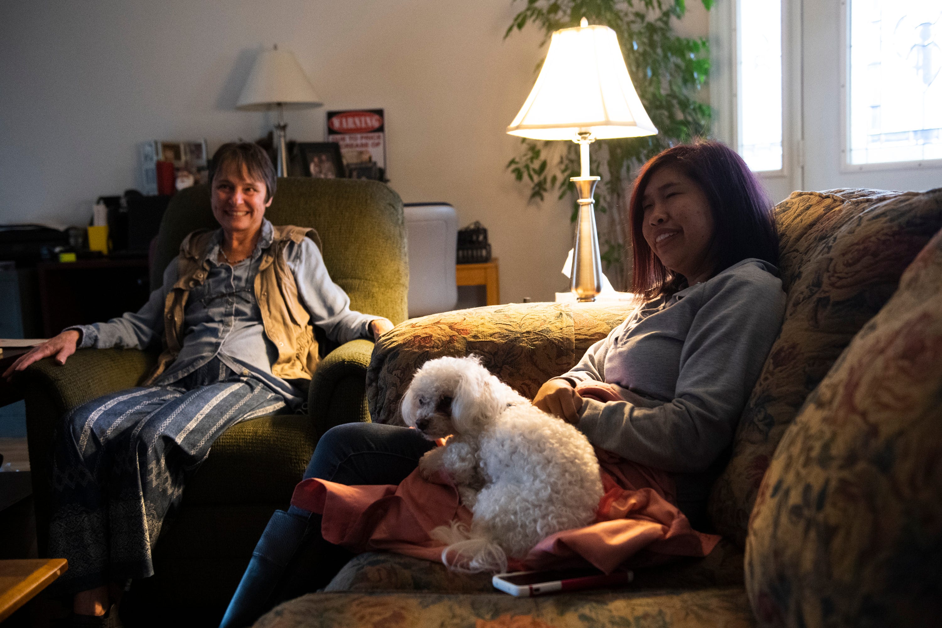 Fatima Quintana sits with Tina Sparks and her dog, Ruffles, in Sparks' home on Monday, March 2, 2020.