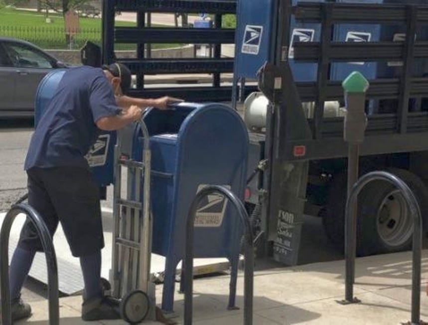 A U.S. Postal Service worker removes a mailbox from a sidewalk in Columbus, Ohio, on Sept. 1. The Postal Service would not confirm if similar actions involving sorting machines or collection boxes had occurred in Polk County. BETHANY BRUNER/COLUMBUS DISPATCH