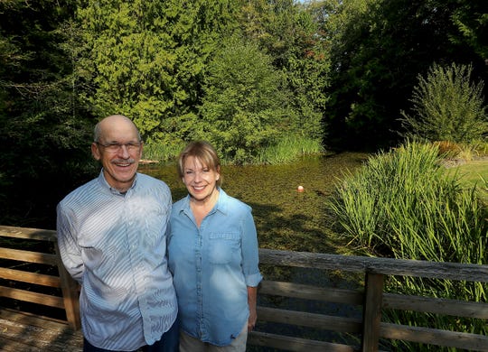 Tom and Marnie Malpass pose for a portrait next to the pond at their Bainbridge Island home in September.