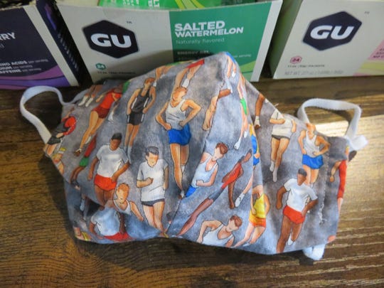This unique mask showing some figures of runners is among the items for sale at The Long Run running apparel store.