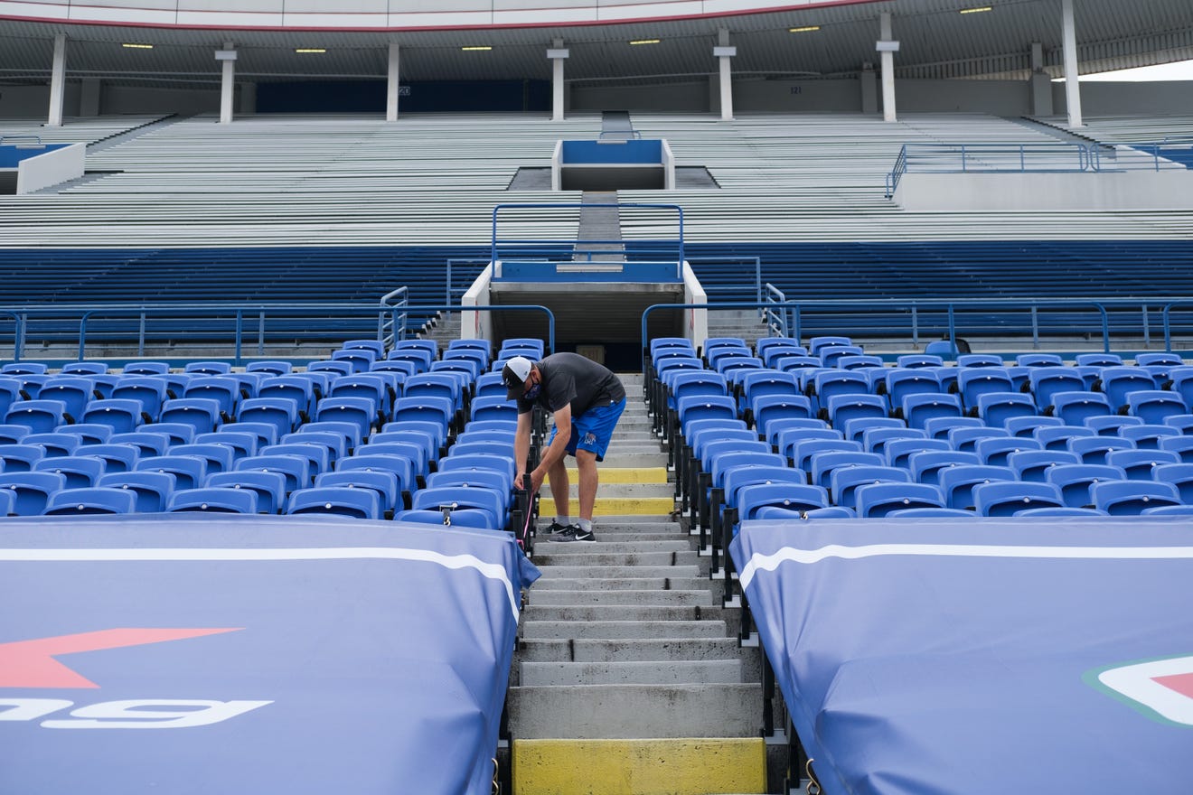 A Liberty Bowl staff member closes off rows of seating in preparation for the Memphis Tigers' season-opening football game, Friday, Sept. 4, 2020, in Memphis, TN.