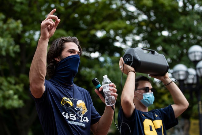 U-M quarterback Dylan McCaffrey leads the singing of  Michigan fight song "Hail to the Victors" outside of Hatcher Graduate Library on the U-M campus in Ann Arbor on Sept. 5, 2020. U-M football players' parents, supporters and some players and coaches march from Michigan Stadium to the central campus to protest the postponement of the fall football season.