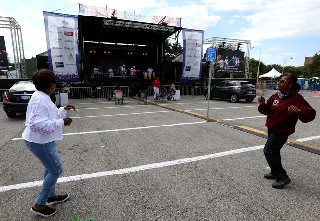 (L to R) Ferne Guillebeaux, 63 of Pensacola, Florida dances with her sister Marsha Guillebeaux of Detroit to the music of the Damon Terrell Band during a drive-in concert series at the scaled down Arts, Beats and Eats in Royal Oak, Michigan on September 5, 2020.