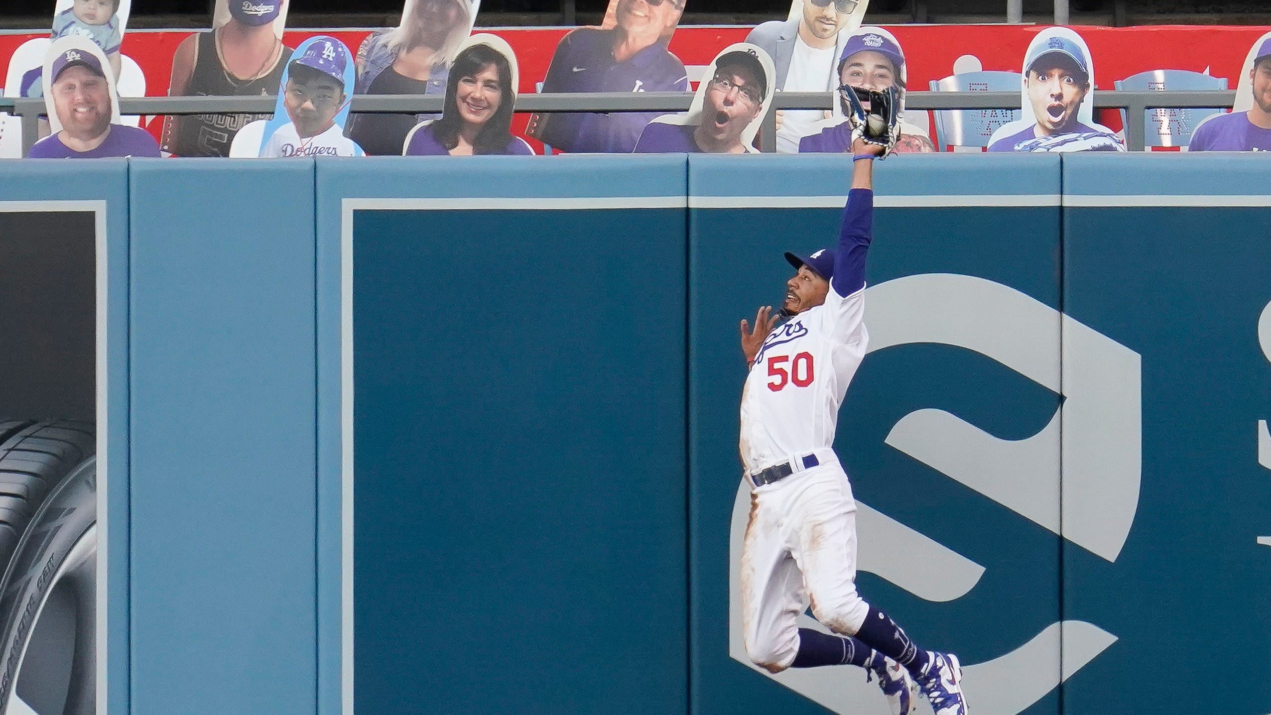 Los Angeles Dodgers right fielder Mookie Betts leaps and makes the catch on a ball hit by Colorado Rockies' Kevin Pillar during the second inning of a baseball game Saturday, Sept. 5, 2020, in Los Angeles.