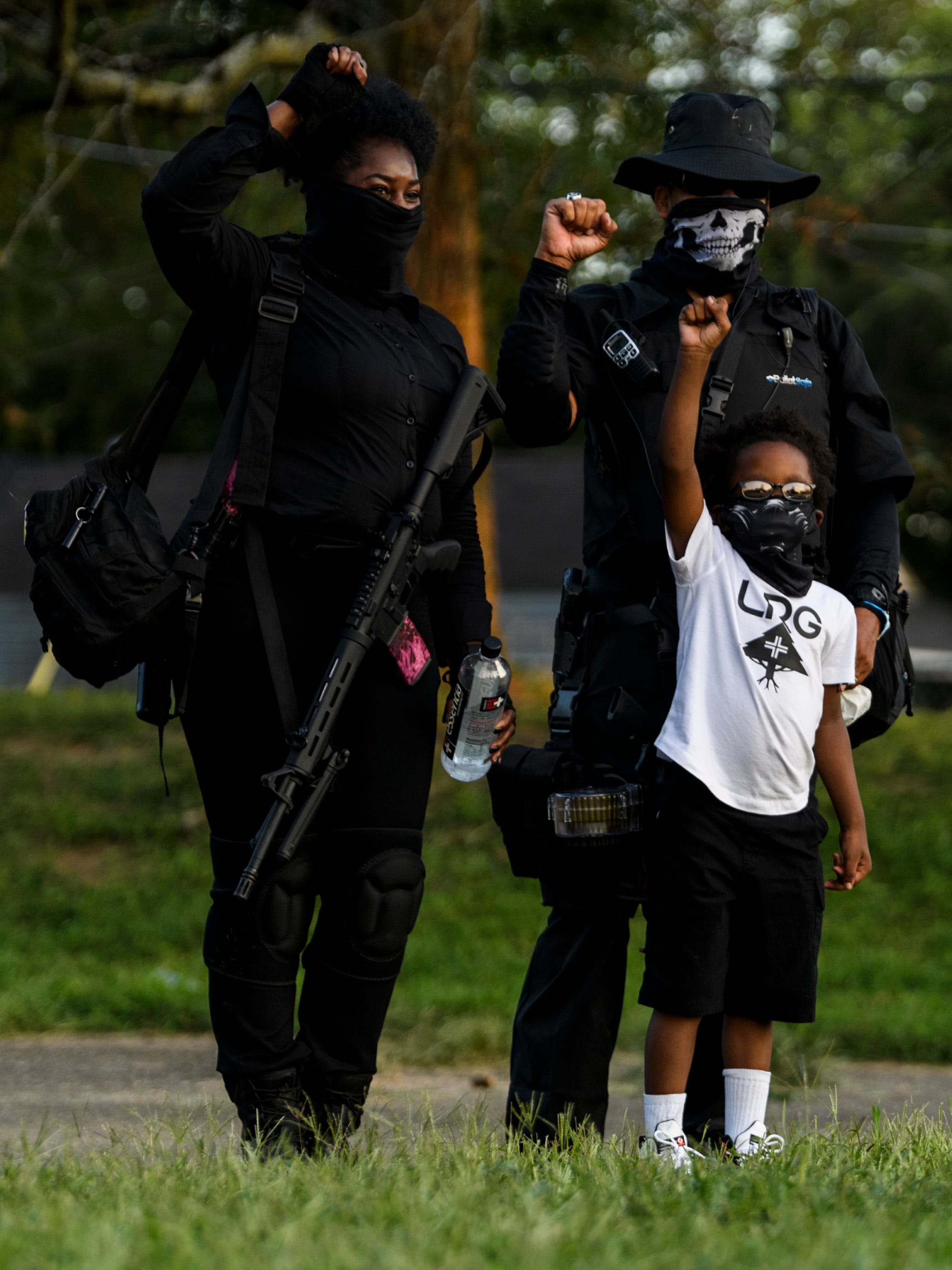 Maliq Madden, 6, of Louisville poses for a picture with members of the Not F***ing Around Coalition militia at G.G. Moore Park after the Derby day protests in Louisville, Ky., Saturday evening, Sept. 5, 2020.
