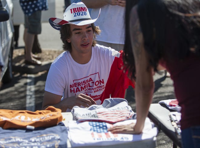Jordan Conradson sells Trump T-shirts at the "Silent No More Red Wave Vehicle Parade," hosted by Colleen Mahoney and Paul Alan Carver Jr.  on Sept. 6, 2020, in Phoenix. Attendees of this event gathered to show their support of President Trump and the Republican Party.