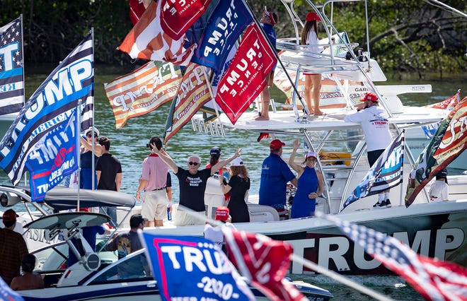 Roger Stone waves from Carlos Gavida's boat as they join hundreds of Trump supporters in Monday's parade from Jupiter to Mar-a-Lago.
