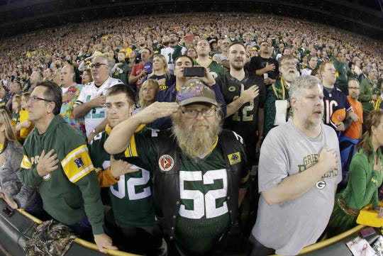 Spectators stand for the national anthem before the Green Bay Packers game against the Chicago Bears Thursday, September 28, 2017 at Lambeau Field in Green Bay, Wis. To demonstrate unity, Green Bay Packers quarterback Aaron Rodgers requested that fans to join players, locking arms in the stands during the national anthem. Some fans are angry at the team and players for what they perceive as showing disrespect for the nation, the flag, the military or the national anthem by sitting, kneeling, remaining in the locker room or locking arms during the national anthem. Supporters say players are peacefully exercising their free speech rights on the best stage available.