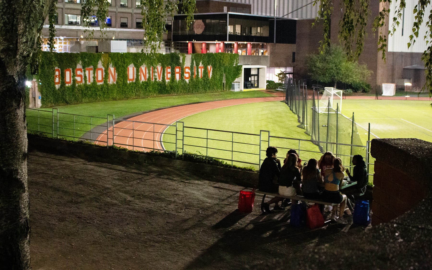 Boston University students spend Thursday evening in small groups outside their dorms at Nickerson Field.